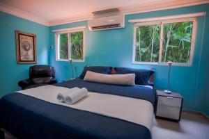 ParaísoImpresionante villa con piscina Metro Country Club的蓝色卧室,配有床和椅子