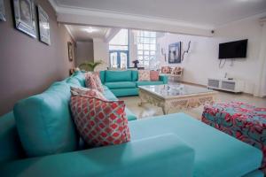 ParaísoImpresionante villa con piscina Metro Country Club的客厅配有蓝色的沙发和桌子