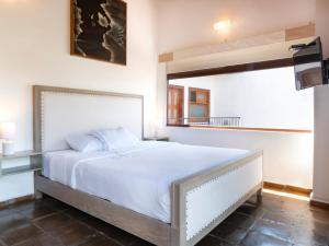 科阿特佩克Hotel Casa Real Del Café的卧室配有白色的床和窗户。