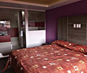 墨西哥城Hotel Rossel Plaza的一间卧室设有一张紫色墙壁的大床