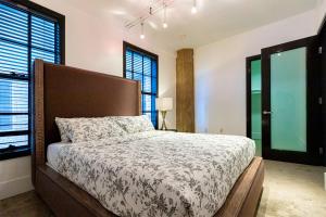 洛杉矶Urban Loft Apartment的一间卧室设有一张大床和两个窗户。