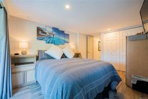 莱迪史密斯Trails End Beach House suite with hot tub and beach bedroom cabin!的一间卧室配有一张带蓝色棉被的床