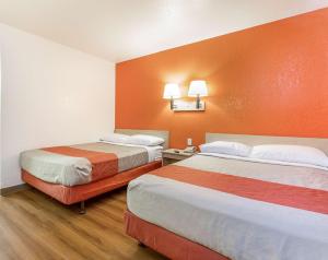 凤凰城菲尼克斯北贝尔路6号汽车旅馆的橙色墙壁的酒店客房内的两张床