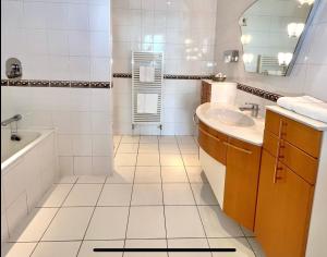 道格拉斯Promenade House的白色的浴室设有浴缸和水槽。