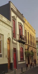 大加那利岛拉斯帕尔马斯Adara Vegueta Exclusive Apartment的一座白色的大建筑,设有红色的门窗