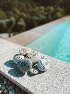 阿尔库什迪瓦尔德维什Quinta do ribeiro的一堆石头,上面写着字,坐在游泳池旁边
