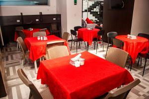 帕斯托Hotel Star Pasto的一间设有红色桌椅的用餐室