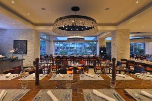 圣何塞InterContinental Costa Rica at Multiplaza Mall, an IHG Hotel的一间带桌椅和吊灯的餐厅