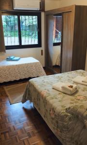 格拉玛多Casa Goldoni Gramado的一间卧室设有两张床和两个窗户。
