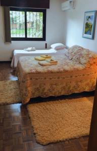 格拉玛多Casa Goldoni Gramado的一间卧室配有床、窗户和床罩