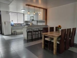 巴尼奥斯Elegante apartamento con vistas al volcán Tungurahua的厨房以及带桌椅的用餐室。