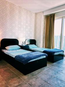 迪拜Travelers Backpackers的两张床位于带窗户的房间内
