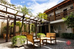 弗洛里亚诺波利斯Hotel Geranius Ingleses的庭院配有木椅和凉亭。