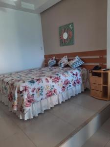 萨尔瓦多Bahia Flat 301的一间卧室配有一张带花卉床罩的床