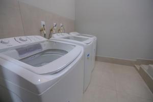 伊瓜苏Vila Nóbrega Residencial的浴室内提供白色洗衣机和烘干机