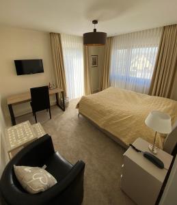明登精美酒店的酒店客房配有一张床、一把椅子和一张书桌