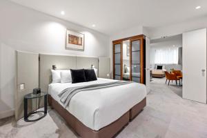 阿德莱德培泊维莫斯酒店的一间带大床的卧室和一间客厅