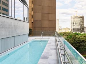 悉尼The Porter House Hotel Sydney - MGallery的建筑物屋顶上的游泳池