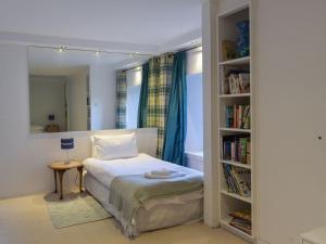 LoanheadTigh Nam Muc的一间卧室设有一张床和一个书架