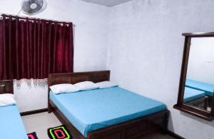 阿努拉德普勒Serene Homestay的小房间设有两张床和镜子