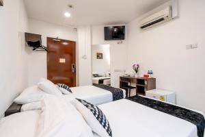 新加坡Tai Hoe Hotel的酒店客房配有两张床和一张书桌