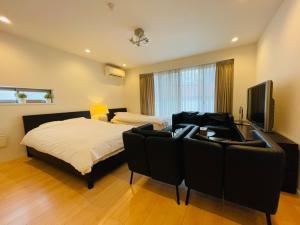 东京SALON渋谷5B的一间卧室配有一张床、一张沙发和一台电视