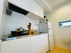 东京SALON渋谷5B的厨房配有白色橱柜和冰箱。
