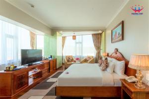 归仁Huong Viet Hotel Quy Nhon - Beachfront的一间卧室配有一张床和一台平面电视
