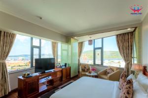 归仁Huong Viet Hotel Quy Nhon - Beachfront的酒店客房设有一张床、一台电视和窗户。
