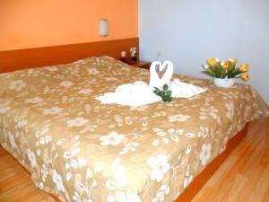 布尔加斯福斯酒店的床上有天鹅,上面有鲜花