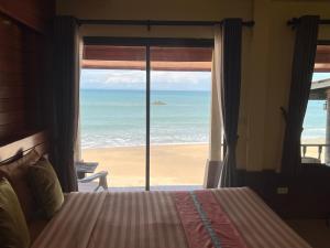 高兰兰达百利宫酒店的一间卧室配有一张床,享有海滩美景