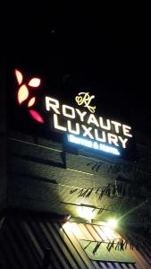 拉合尔Royaute Luxury Suites and Hotel Gulberg Lahore的建筑物一侧的 ⁇ 虹灯标志