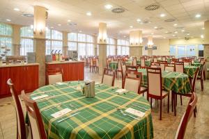 豪伊杜索博斯洛汉加罗斯帕温泉酒店的用餐室配有桌椅和绿色桌布