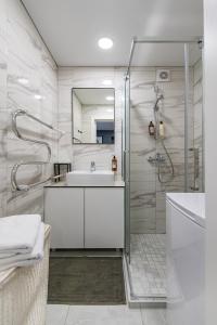 考纳斯RIVERFRONT 2BD Old Town Apartment by Hostlovers的白色的浴室设有水槽和淋浴。