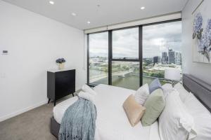 布里斯班1404 Sophistication and Luxury on the Brisbane River by Stylish Stays的卧室设有白色的床和大窗户