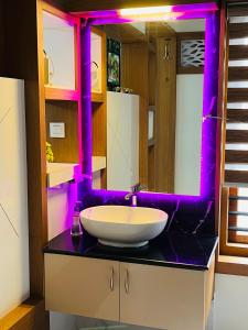 瓦亚纳德Milaano Orchids, Service Villa, Kammana Mananthavady的浴室设有白色水槽和紫色照明