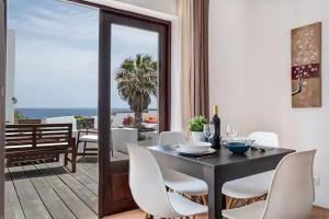 TabayescoPlaya Marina Eco Bungalow – Arrieta View的一间带桌椅的用餐室和一个阳台