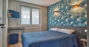 圣让-德蒙阿特兰提克酒店及餐厅的一间卧室配有一张带蓝色棉被的床