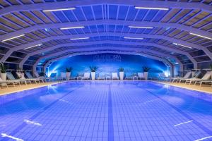 里乔内大西洋酒店的一个带椅子和天花板的大型游泳池