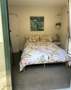 基督城City Stay的一间卧室配有一张带花卉床罩的床