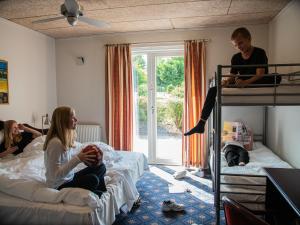 布勒鲁普索伽登布鲁普酒店的一组人在卧室里,卧室里配有双层床
