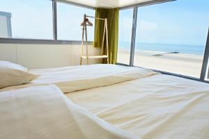 栋堡Slaapzand的一间卧室配有一张床,享有海滩美景