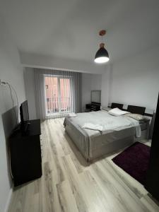 雅西Apartament de lux intr-o zona rezidentiala linistita的一间白色卧室,配有床和电视