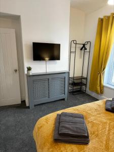 米德尔斯伯勒Byelands House的一间卧室配有一张床和一台平面电视