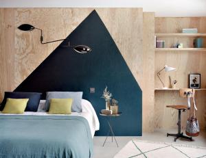 巴黎亨丽埃特酒店的一间卧室配有一张蓝色的床和黑色的墙壁