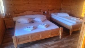 ChişcăuCabanuțele din Lemn的配有2张床的带白色床单和枕头的客房