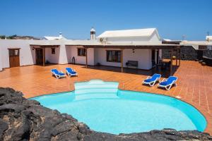 圣巴尔托洛梅Casa Lola Lanzarote piscina climatizada y wifi free的一座带游泳池和躺椅的房屋