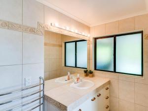 TangoioTango10 Accommodation - Best views in Hawke's Bay的一间带水槽的浴室和两个窗户