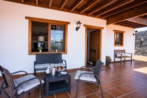 圣巴尔托洛梅Casa Lola Lanzarote piscina climatizada y wifi free的门廊配有椅子和桌子,设有窗户