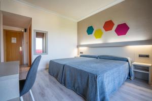米兰达德埃布罗图丹卡米兰达酒店的一间卧室配有一张带蓝色毯子的床